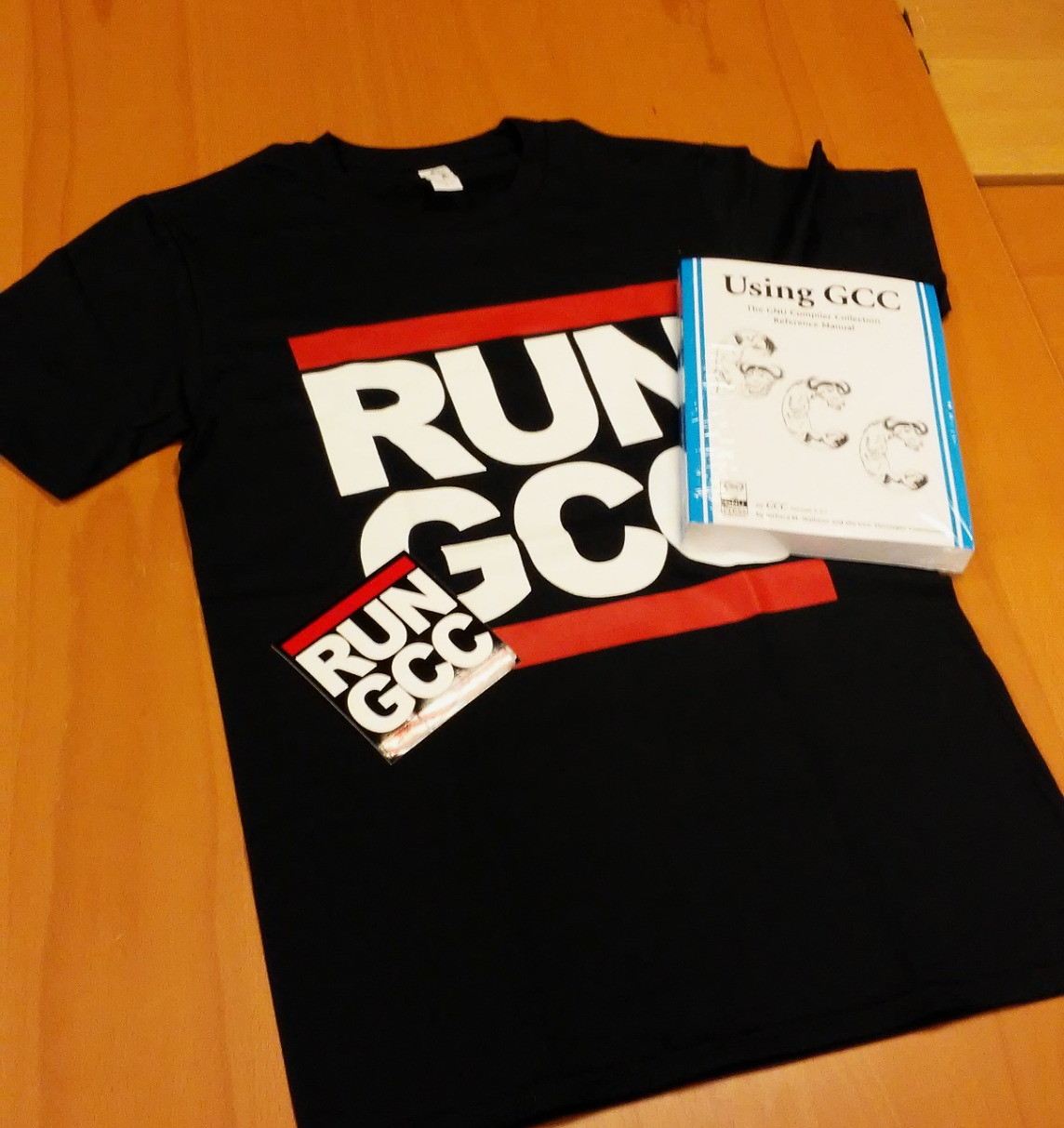 A RUN GCC shirt, a GCC manual, and a RUN GCC sticker