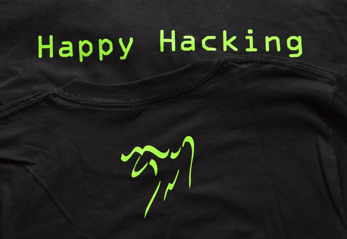 A black t-shirt with a green terminal font saying "Happy Hacking", and a green Emacs gnu logo
