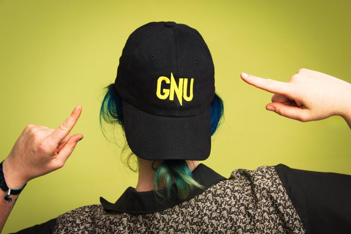 View from behind someone wearing a backwards hat with the word "GNU"