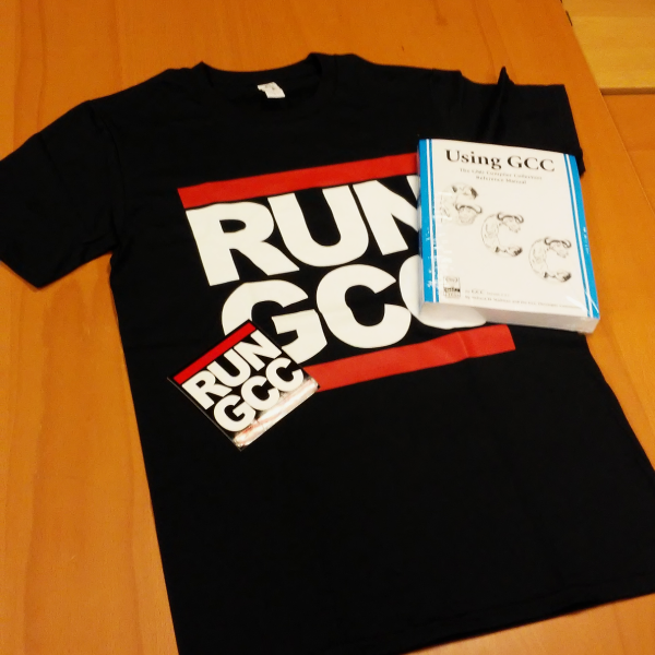 A RUN GCC shirt, a GCC manual, and a RUN GCC sticker